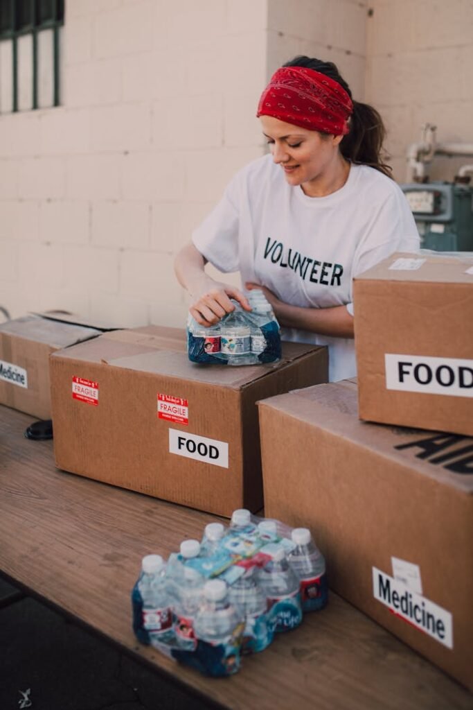 A Woman Holding Bottles of Drinks on Top of a Brown Box